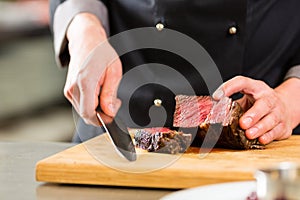 Chef in hotel or restaurant kitchen cooking