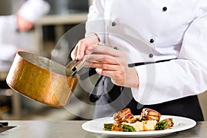 Chef in hotel or restaurant kitchen cooking