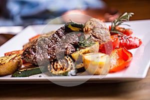 Chef in hotel or restaurant kitchen cooking only hands. Prepared beef steak with vegetable decoration