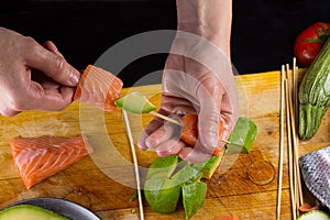 Chef is implating salmon filtet on a skewer