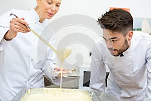 Chef inspecting white chocolate consistency