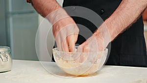Chef kneading dough in bowl