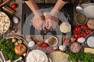 Chef kneading dough for bread, pizza, pasta with ingredients, top view, food preparation process. Delicious food, cooking and