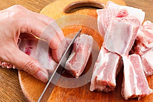 Cocinero un cuchillo cortes crudo cerdo costillas sobre el lámina 