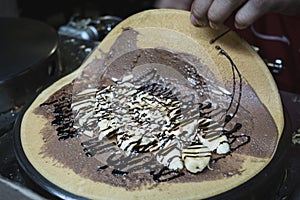 Chef makes chocolate banana crepe on hot pan