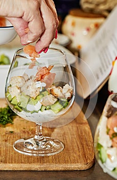 Chef makes Summer salad in glass of salmon, cucumbers, croutons, herbs and fresh cream, Elegant Summer Fusion