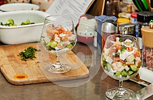 Chef makes Summer salad in glass of salmon, cucumbers, croutons, herbs and fresh cream, Elegant Summer Fusion