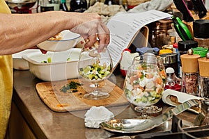 Chef makes Summer salad in glass of salmon, cucumbers, croutons, herbs and fresh cream, Elegant Summer Fusion