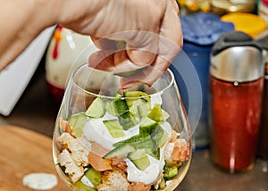 Chef makes Summer salad in glass of salmon, cucumbers, croutons, herbs and fresh cream, Elegant Summer Fusion