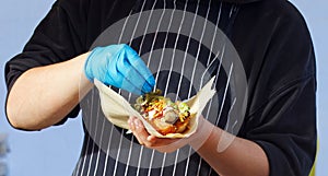 Chef making hot dog for a customer at farmers market.