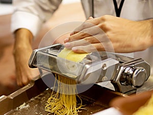 Chef making pasta with a machine, home made fresh pasta