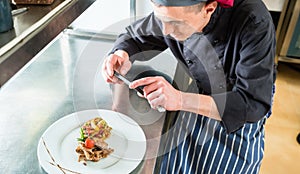 Chef making picture of food he cooked with phone