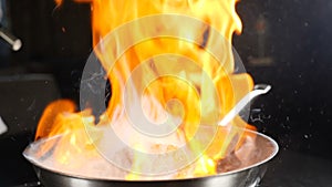 Chef making steak fillet mignon in flambe style on a grill pan. Cooking in restaurant in slow motion. Cooking Beef meat