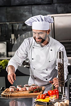 Chef male prepare steak at kitchen. Happy chef cook meat at kitchen restaurant.