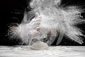 Chef man clap hand and white flour dust on black background