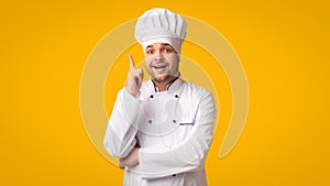 Chef Man Pointing Finger Up Having Idea Standing, Yellow Background
