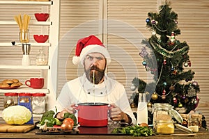 Chef man in santa claus hat cooking.