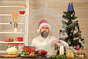 Chef man in santa claus hat cooking.