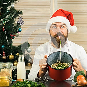 Chef man in santa claus hat cooking.