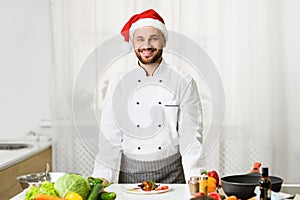 Chef Man In Santa Hat Smiling Standing In Kitchen