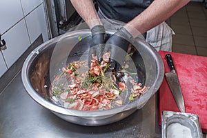 The chef marinates pork meat. Delicious food in the restaurant.