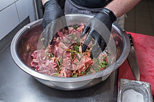 The chef marinates pork meat. Delicious food in the restaurant.