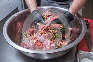 The chef marinates pork meat. Delicious food in the restaurant.