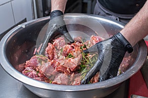 The chef marinates pork meat. Delicious food in the restaurant.