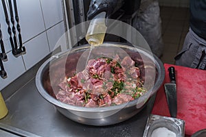 The chef marinates pork meat. Delicious food in the restaurant.