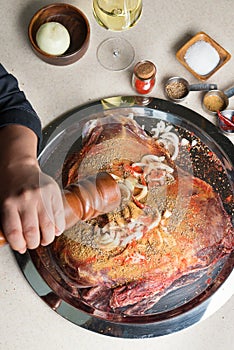 Chef marinating a big piece of meat