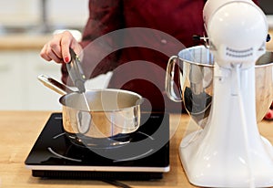 Chef measuring temperature in pot at kitchen