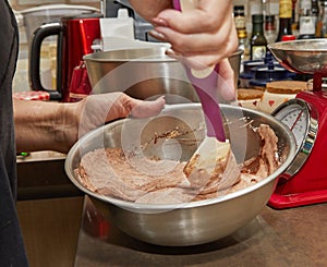 Chef mixes cocoa, flour with the rest of the ingredients in bowl for making pie