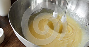 Chef mixing ingredients in bowl cooking dough baking cake using electric mixer.