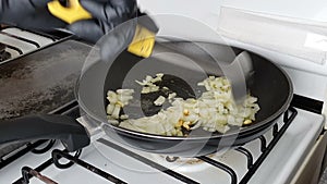 Chef mixing onion and garlic in a pan