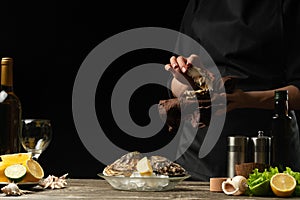 The chef opens an oyster on a background of white wine, lettuce, lemons and limes. With space for an inscription