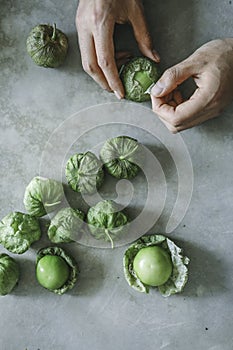 Chef peeling fresh green tomatillos