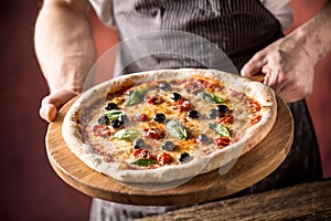 Chef and pizza. Chef offering pizza in hotel or restaurant