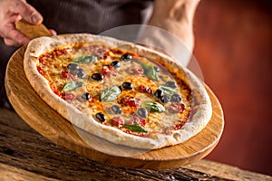 Chef and pizza. Chef offering pizza in hotel or restaurant