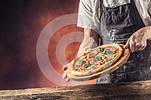 Chef and pizza. Chef offering pizza in hotel or restaurant