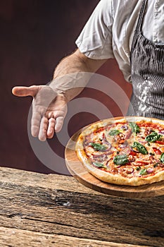 Chef and pizza. Chef offering pizza in hotel or restaurant