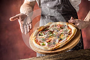 Chef and pizza. Chef offering pizza in hotel or restaurant