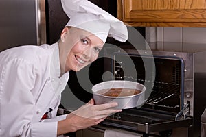 Chef places cake in oven