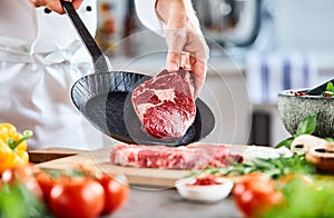 Chef placing a thick tender rump steak in a pan