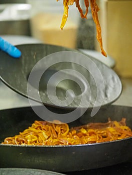 chef plating tagliatelle sauce pasta into black design dishes - mise en place