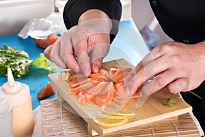 Chef plating up raw salmon for sashimi