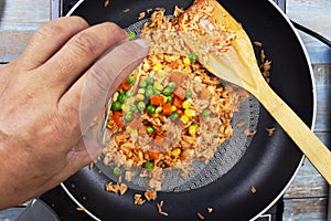 Chef pouring carrot,green bean and corn for cook fried rice