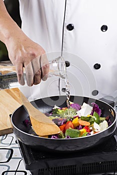 Chef pouring soup to the pan