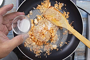 Chef pouring sugar to pan for cook fried rice