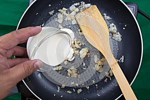 Chef pouring Whipping cream to the pan / cooking spaghetti conce