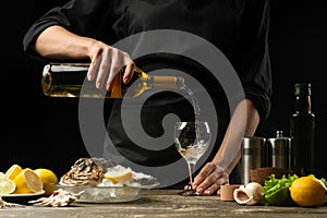 Chef pours, tastes Italian dry oyster wine with lemon photo